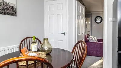 a dining room table with a bottle of wine on it at Mill Charm in Barrow in Furness