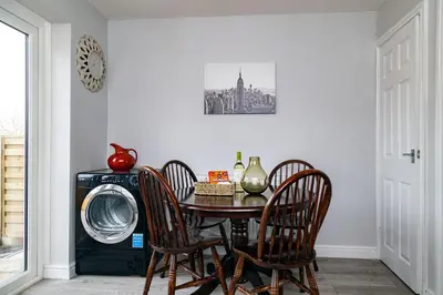 a dining room table with chairs and a washing machine at Mill Charm in Barrow in Furness