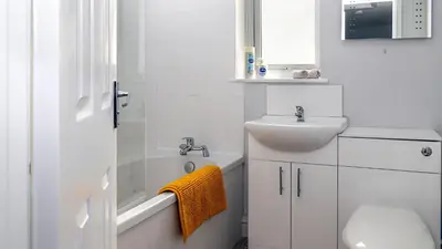 a bathroom with a sink and a toilet and a bath tub at Mill Charm in Barrow in Furness