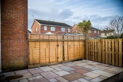 a wooden fence in front of a house at Mill Charm in Barrow in Furness