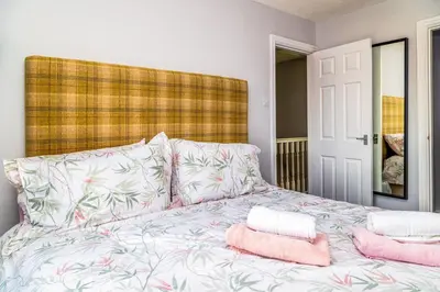 a bedroom with a bed with pink pillows at Mill Charm in Barrow in Furness