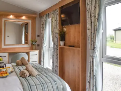 a bedroom with a bed with a tv and a window at Lake View - Uk36811 in Whalley