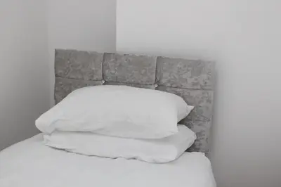 a pile of white pillows sitting on top of a bed at Morning Star Home in Liverpool