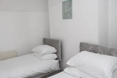 a bedroom with a bed with white sheets and pillows at Morning Star Home in Liverpool