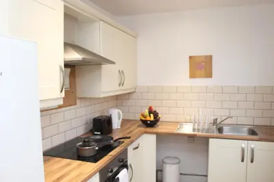 a kitchen with white cabinets and a bowl of fruit on the counter at Morning Star Home in Liverpool