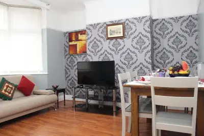 a living room with a table and a television at Morning Star Home in Liverpool