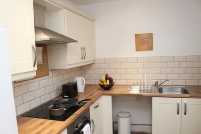 a kitchen with white cabinets and a bowl of fruit on the counter at Morning Star Home in Liverpool