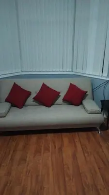a couch with four red pillows on it at Morning Star Home in Liverpool