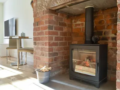 a brick fireplace with a stove in a room at Sandend in Lytham St Annes