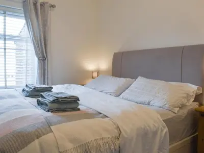 a bed with two towels sitting on top of it at Sandend in Lytham St Annes