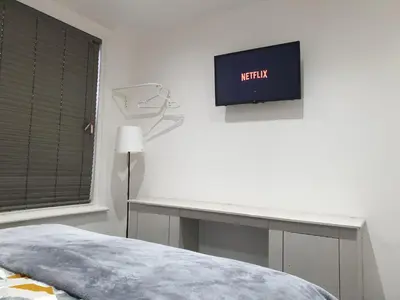 a bedroom with a desk and a tv on the wall at Stunning 5 bed house, 2 mins to beach and town, with free parking in Blackpool