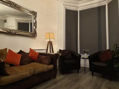 a living room with a couch and two chairs at Stunning 5 bed house, 2 mins to beach and town, with free parking in Blackpool