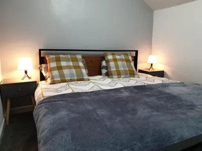 a bedroom with a large bed with two lamps at Stunning 5 bed house, 2 mins to beach and town, with free parking in Blackpool