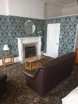 a living room with a couch and a fireplace at Eden Vale Ground Floor Sea View Apartment in Morecambe