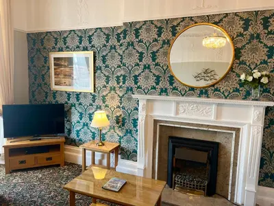 a living room with a fireplace and a mirror at Eden Vale Ground Floor Sea View Apartment in Morecambe