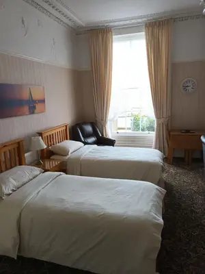 a hotel room with two beds and a window at Eden Vale Ground Floor Sea View Apartment in Morecambe