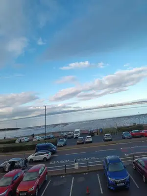 a parking lot with cars parked next to the beach at Eden Vale Ground Floor Sea View Apartment in Morecambe