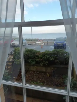 a window with a view of a parking lot at Eden Vale Ground Floor Sea View Apartment in Morecambe