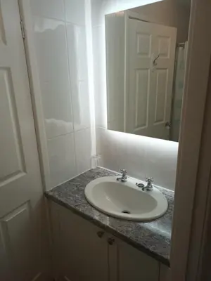 a bathroom with a sink and a mirror at Eden Vale Ground Floor Sea View Apartment in Morecambe
