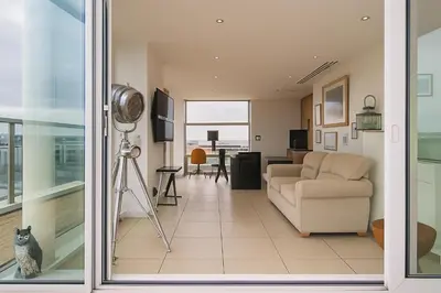 a living room with a couch and a table at Sidemersey Livings- Unmatched Panoramic Views, Secure Parking, Beautiful Balcony- A Stay to Remember in Liverpool