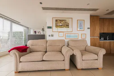 a living room with a couch and two chairs at Sidemersey Livings- Unmatched Panoramic Views, Secure Parking, Beautiful Balcony- A Stay to Remember in Liverpool