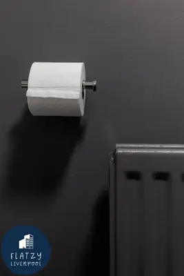 a roll of toilet paper hanging on a wall at FLATZY - Modern Apartment Close to Football Stadiums in Liverpool