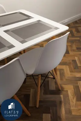 a white table with two white chairs in a room at FLATZY - Modern Apartment Close to Football Stadiums in Liverpool