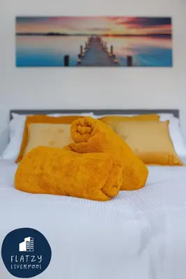 a stuffed animal laying on top of a bed at FLATZY - Modern Apartment Close to Football Stadiums in Liverpool