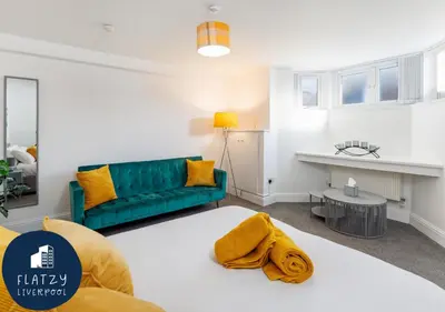 a living room with a couch and a table at FLATZY - Modern Apartment Close to Football Stadiums in Liverpool