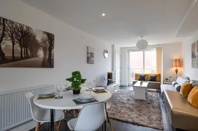 a white living room with a table and a couch at Stanley Sparkle Stays - 4BRooms, 4Beds, Prkg, Wifi in Liverpool