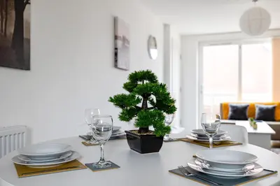 a table with plates and glasses and a tree on it at Stanley Sparkle Stays - 4BRooms, 4Beds, Prkg, Wifi in Liverpool