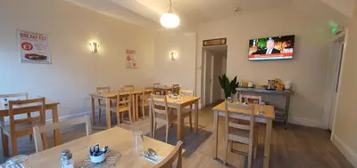 a restaurant with wooden tables and chairs and a tv at Blackpool North Close to Station - With Free Car Parking in Blackpool