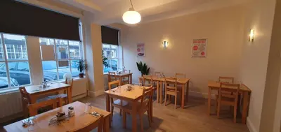 a restaurant with wooden tables and chairs and windows at Blackpool North Close to Station - With Free Car Parking in Blackpool