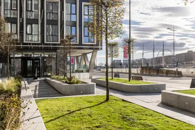 a building with benches and trees in a park at Copper House in Liverpool in Liverpool