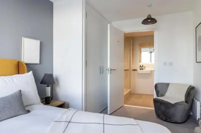 a bedroom with a white bed and a chair at Copper House in Liverpool in Liverpool