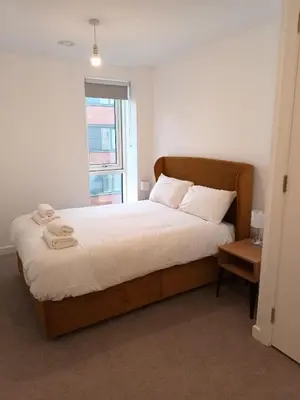 a bedroom with a bed with white sheets and a window at Copper House in Liverpool in Liverpool