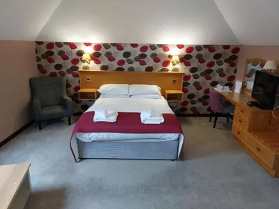 a bedroom with a bed and a desk and a television at The County Lodge in Carnforth