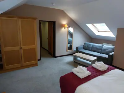 a bedroom with a bed and a couch in a room at The County Lodge in Carnforth