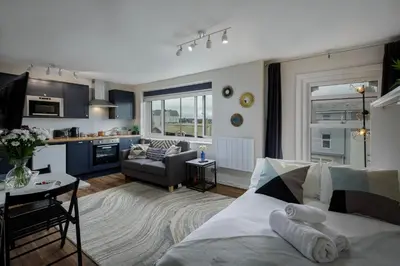 a living room and kitchen with a bed and a table at Lunar Stays in Blackpool