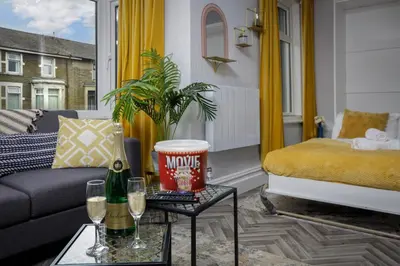 a living room with a couch and a table with wine glasses at Lunar Stays in Blackpool