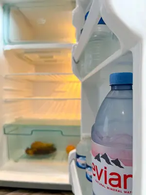 a bottle of water sitting in front of an open refrigerator at Lunar Stays in Blackpool