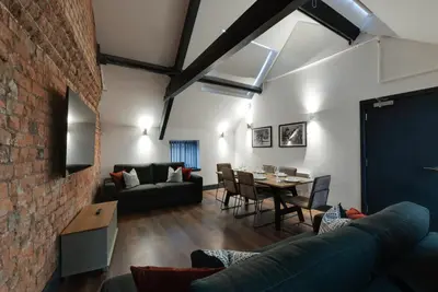 a living room with a couch and a table at Harrisons Aparthotel Liverpool in Liverpool