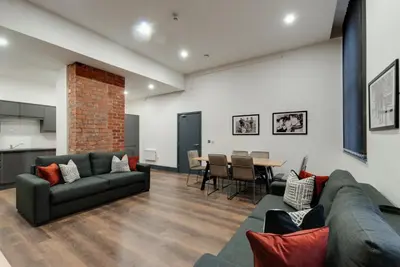 a living room with a couch and a table at Harrisons Aparthotel Liverpool in Liverpool