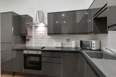 a kitchen with stainless steel appliances and a sink at Harrisons Aparthotel Liverpool in Liverpool