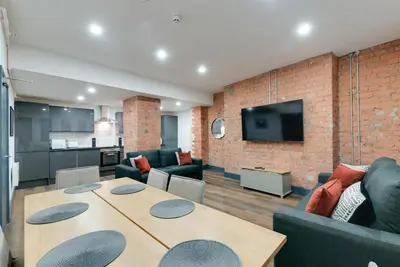 a living room with a table and a couch at Harrisons Aparthotel Liverpool in Liverpool