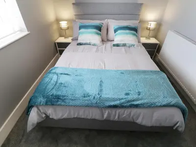 a bedroom with a large bed with blue and white pillows at White Stones in Ulverston