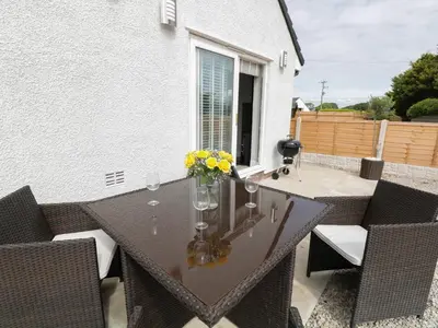 a table with a vase of flowers on a patio at White Stones in Ulverston