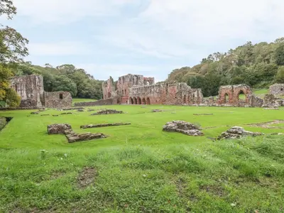 an old castle in a field with grass and rocks at White Stones in Ulverston