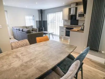 a kitchen and living room with a table and chairs at White Stones in Ulverston