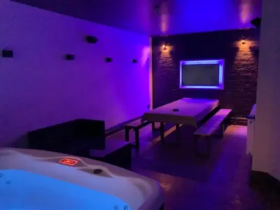 a room with purple lighting and a table and a bed at Saltrock luxury apartment in Blackpool
